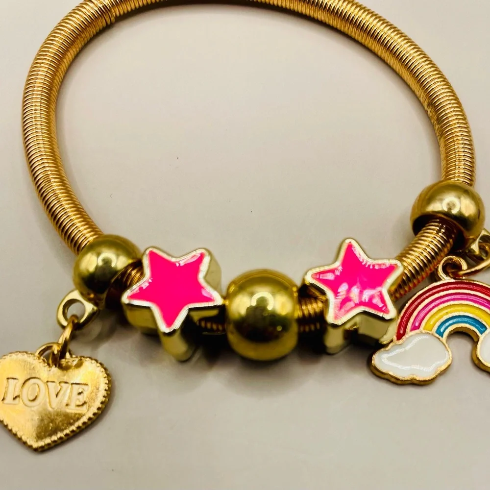 Yellow gold plated spring baby bangle with rainbow, heart and star charms.